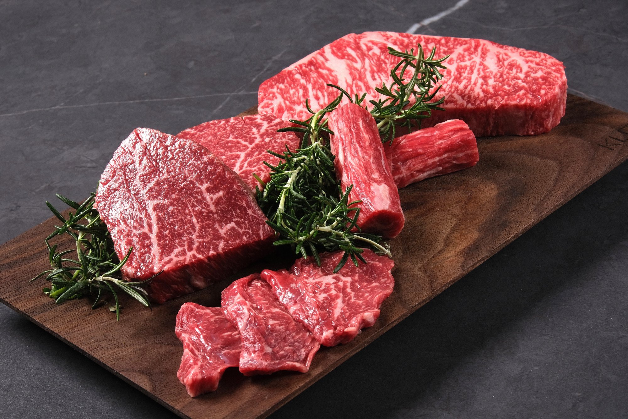Premium BMS no.9 hanwoo cuts — top-grade Korean beef hand-selected and chef-cut for KUT SEOUL's tasting menu, presented on a walnut board with rosemary.