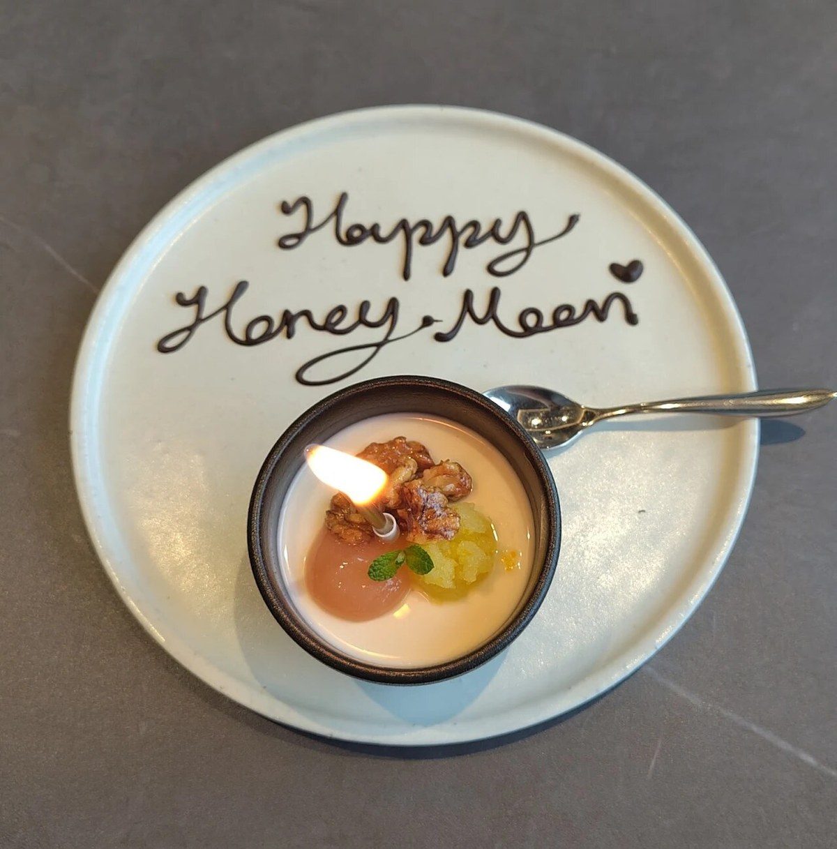A 'Happy Honey Moon' chocolate-scripted dessert plate at KUT SEOUL — a candle-lit petit-fours course quietly prepared for newlyweds dining in a private hanwoo omakase room in Jongno, Seoul.